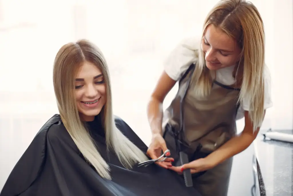 Fryzjerka strzygąca włosy klientki w salonie fryzjerskim