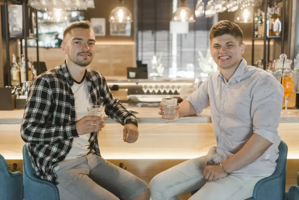 Dwaj koledzy wznoszą toast przy stoliku
