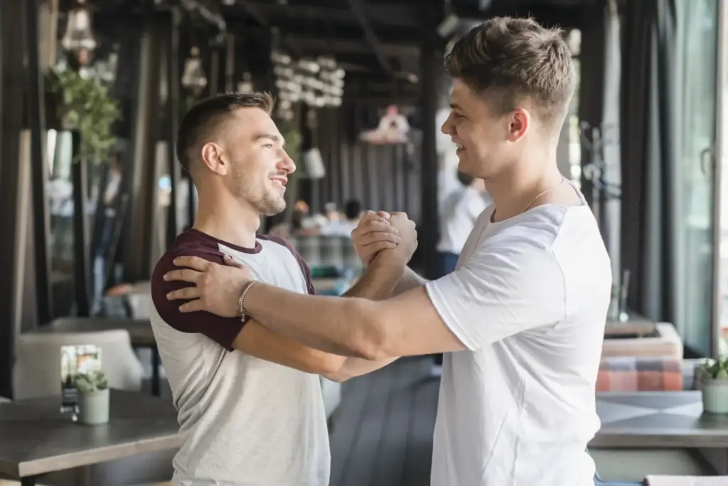 Dwaj mężczyźni podają sobie dłonie przy stole
